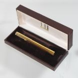 A Dunhill gold plated fountain pen, with a gold nib marked 18 carat,
