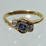 An 18 carat gold diamond and sapphire ring, of crossover design,