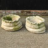 A pair of reconstituted stone planters in the form of sacks,