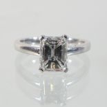 An 18 carat white gold diamond ring, set with an emerald cut stone, approximately 1.