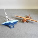 A wooden model of an airplane, together with a painted wooden pond yacht,