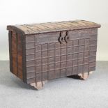 An Indian iron bound hardwood trunk, with a hinged lid, on wheels,