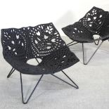 A pair of large black designer armchairs, on Metal legs,