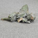 A painted metal figure of a sleeping fairy,