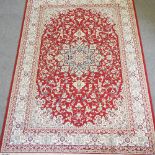 A Keshan style carpet, on a red ground,