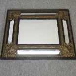 An ornate black and gilt framed wall mirror,
