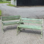 A pair of new green painted cast iron garden benches, with slatted wooden seats,
