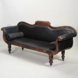 A Regency carved mahogany scroll end sofa, upholstered in black, on turned legs and castors,