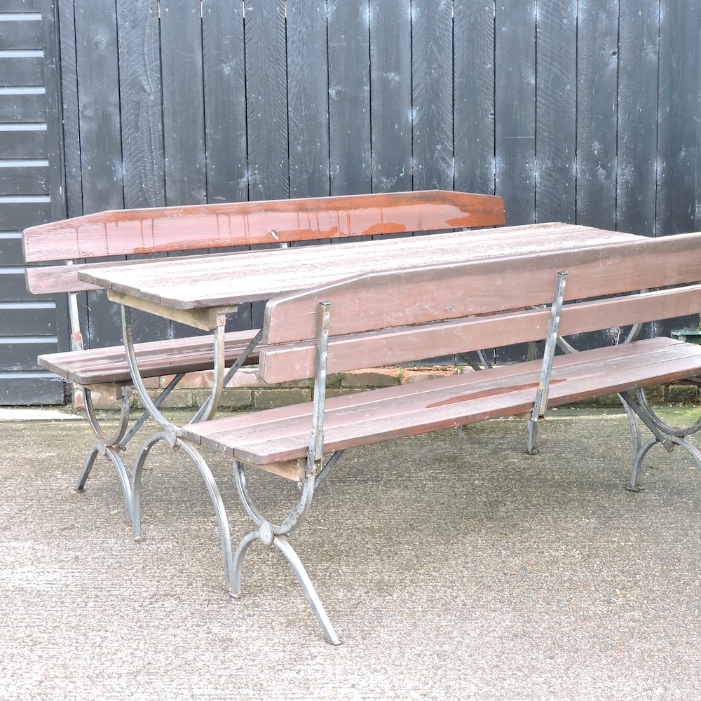 A Bierkeller style folding garden table, together with a pair of matching folding benches,