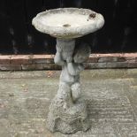 A reconstituted stone bird bath, in the form of a cherub,