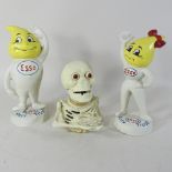 A painted metal skeleton money box, together with a pair of esso money boxes,