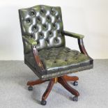 A green leather button back revolving desk chair