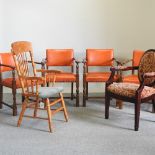 A set of four orange upholstered dining chairs, with arms,