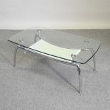 A contemporary chrome coffee table, with glass top,
