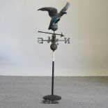 A copper weather vane, surmounted by an eagle, on a stand,