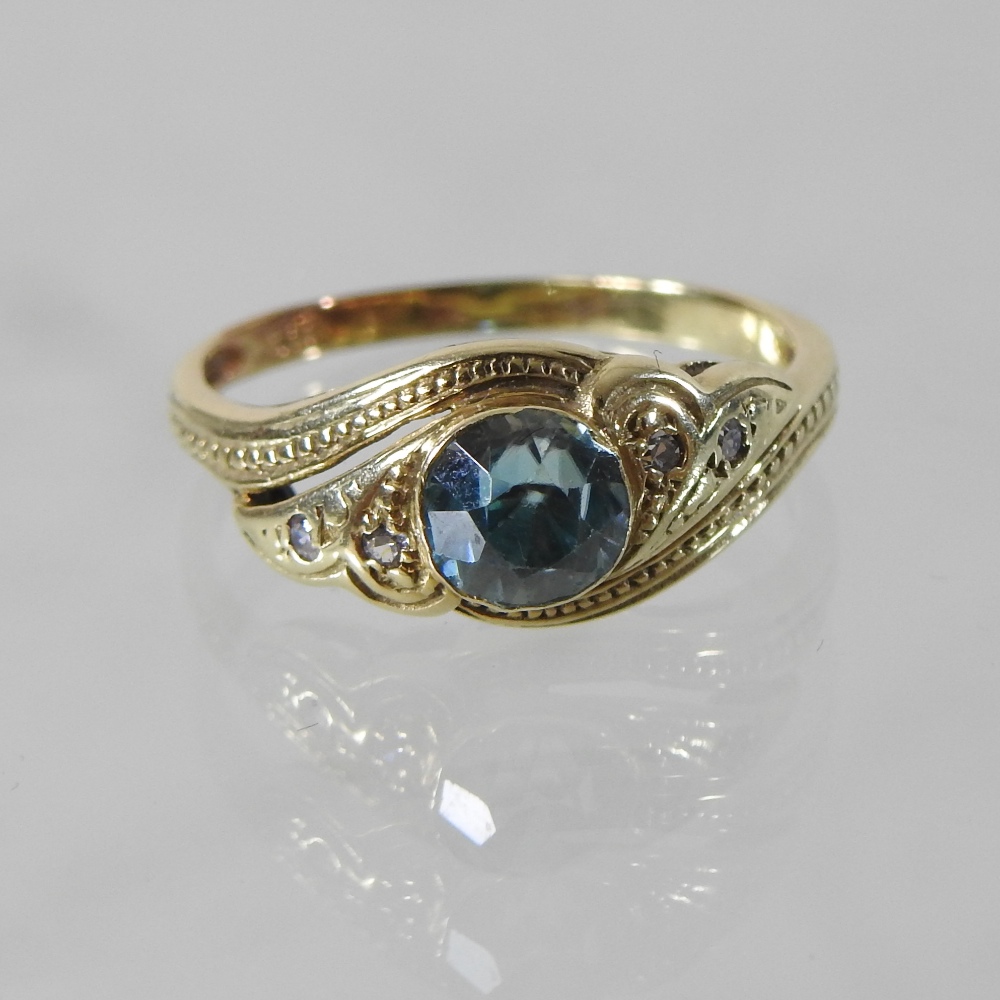 A 14 carat gold and blue zircon and diamond ring, of asymmetrical design,