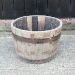 A coopered wooden half barrel planter,