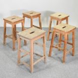 A collection of five various elm laboratory stools,
