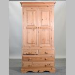 A modern pine double wardrobe, with drawers below,