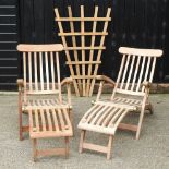 A pair of teak sun loungers, together with a garden trellis,