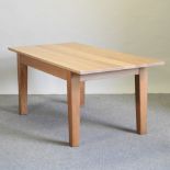 A modern light oak dining table, on square legs,