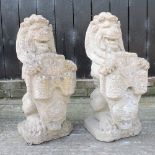 A pair of reconstituted stone garden statues of lions, resting on shields,