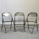 A set of three vintage style metal folding chairs