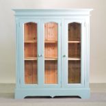 A blue painted pine cabinet, with glazed doors, fitted with shelves,