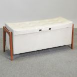 A 1960's padded white vinyl and teak ottoman,