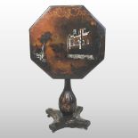 A 19th century black papier-mache occasional table, with a hinged octagonal top, on a platform base,