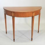 An Edwardian satinwood half round side table, on square tapered legs,