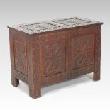An unusual Edwardian carved oak coffer, of panelled construction,