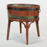 A Georgian style brass bound wine cooler, of coopered oval shape, on a splayed base,