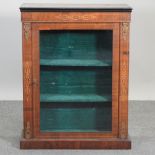 A Victorian walnut pier cabinet, enclosed by a glazed door,