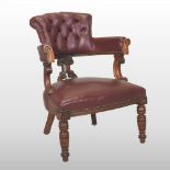 A Victorian carved oak and leather upholstered desk chair, with a buttoned back,