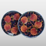 A pair of Moorcroft pottery chargers, each of circular shape, decorated in the Pomegranate pattern,