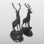 A pair of bronze models of stags, each shown standing, on an oval base,