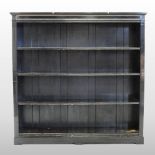 A Victorian ebonised dwarf open bookcase, fitted with adjustable shelves,