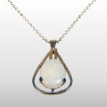 A modern white opal pendant, mounted in 9 carat gold, on a fine 9 carat gold chain,