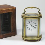 An early 20th century French brass cased carriage clock, of oval shape, with a white enamel dial,
