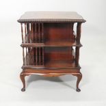A 1920's mahogany revolving bookcase, of square serpentine shape, with a gadrooned edge,