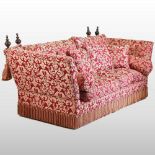 A red and gold upholstered knole sofa, with loose cushions,