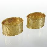 A pair of 9 carat gold napkin rings, of oval textured design, with reeded borders, in a fitted case,