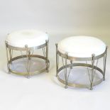 A pair of circular stools, each in the form of a drum, with a cream upholstered seat,