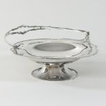 An early 20th century silver sweetmeat basket, with a swing handle, on a pedestal foot, London 1917,