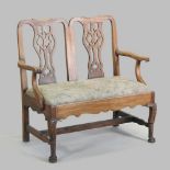 An Edwardian carved walnut chair back settee, of Chippendale design, with a tapestry seat,