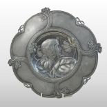 An Art Nouveau pewter plaque, decorated in relief with the profile of a young girl,