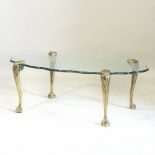 A French style brass coffee table, with a shaped oval glass top, on brass cabriole legs,
