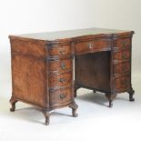 An early 20th century burr walnut serpentine pedestal desk,