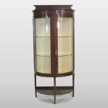 An Edwardian mahogany bow front glazed display cabinet, on a splayed base,